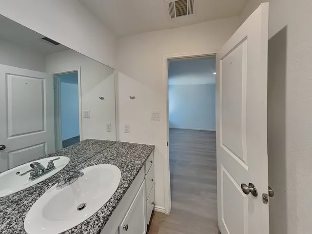 a bathroom with a granite countertop tub sink and mirror