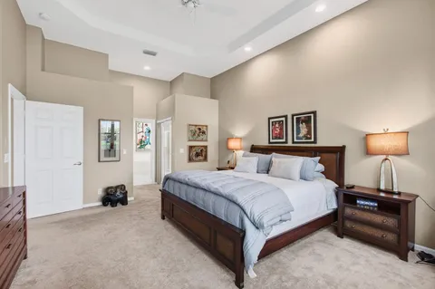 a spacious bedroom with a bed and a lamp