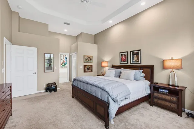 a spacious bedroom with a bed and a lamp