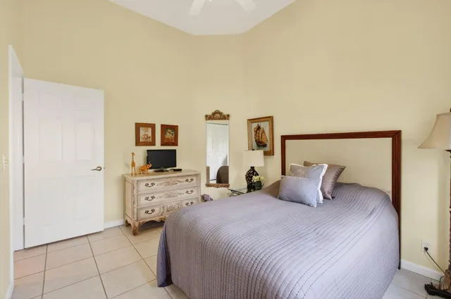 a bedroom with a bed and a flat tv screen on dresser