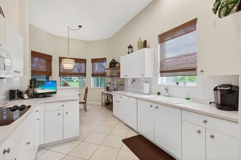 a kitchen with white cabinets and sink