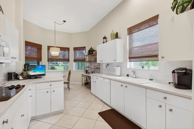 a kitchen with white cabinets and sink