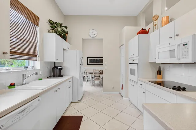 a kitchen with white cabinets and appliances