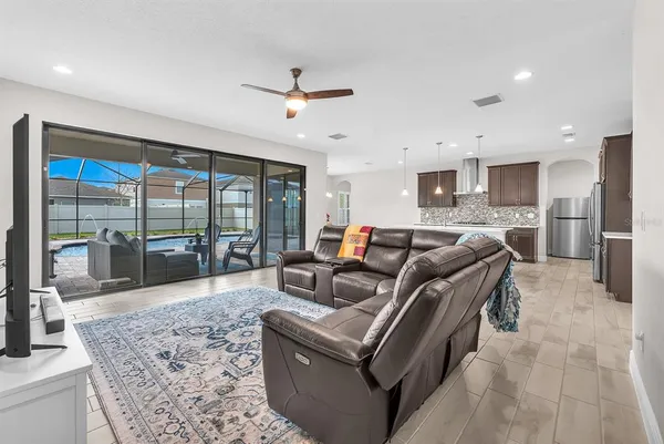 a living room with furniture floor to ceiling window and wooden floor