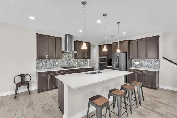 a kitchen with stainless steel appliances a sink stove and refrigerator
