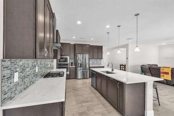 a kitchen with a sink a counter top space stainless steel appliances and cabinets