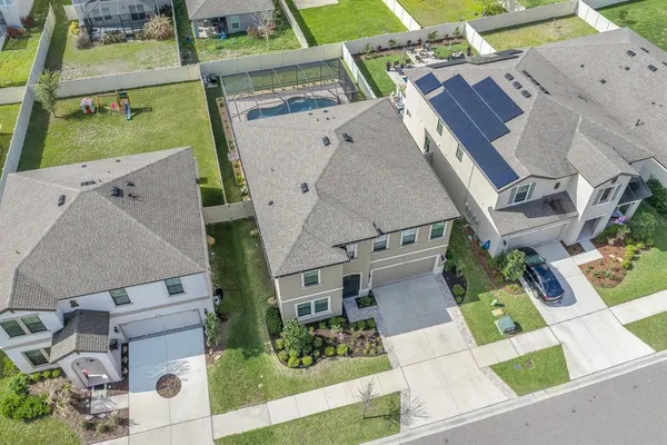 an aerial view of a house a yard and cars