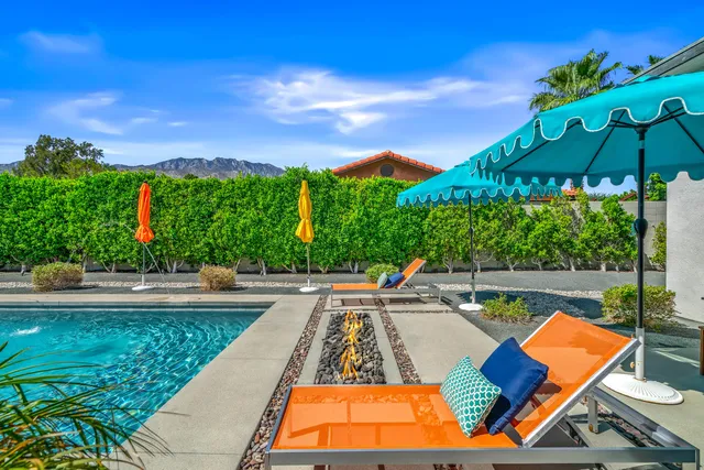 a view of a patio with a table and chairs under an umbrella