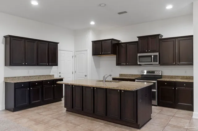 a kitchen with stainless steel appliances granite countertop a stove microwave and sink