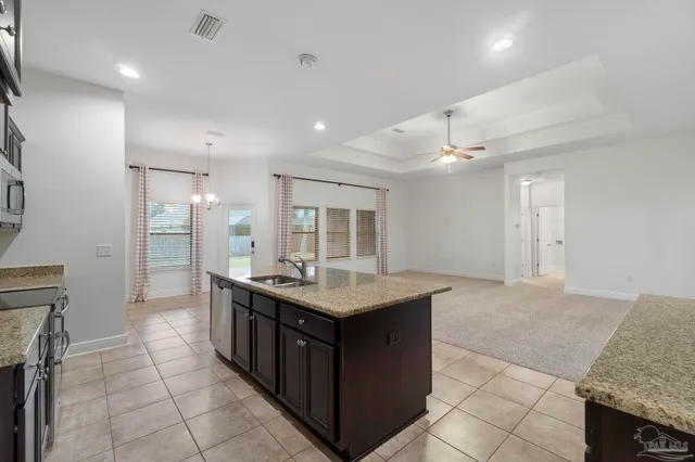 a kitchen with granite countertop counter top space appliances and a center island