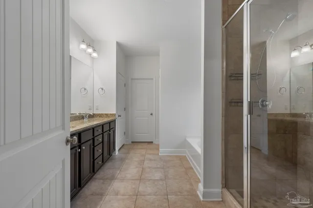 a bathroom with a double vanity sink a toilet and shower