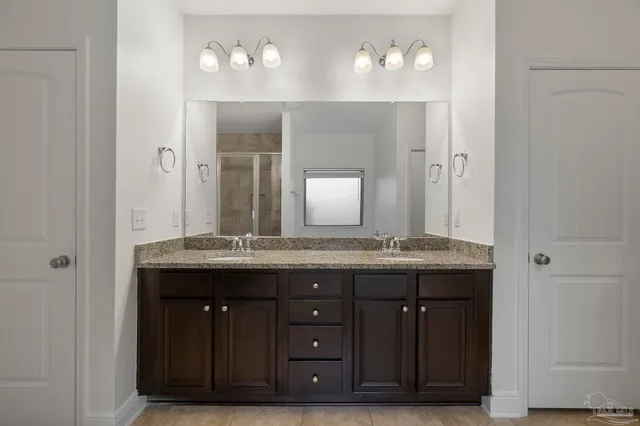 a bathroom with a granite countertop sink a large mirror and a vanity