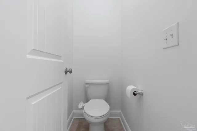 a white toilet sitting next to a white wall