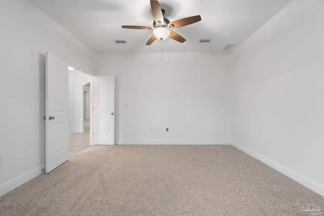 an empty room with chandelier fan