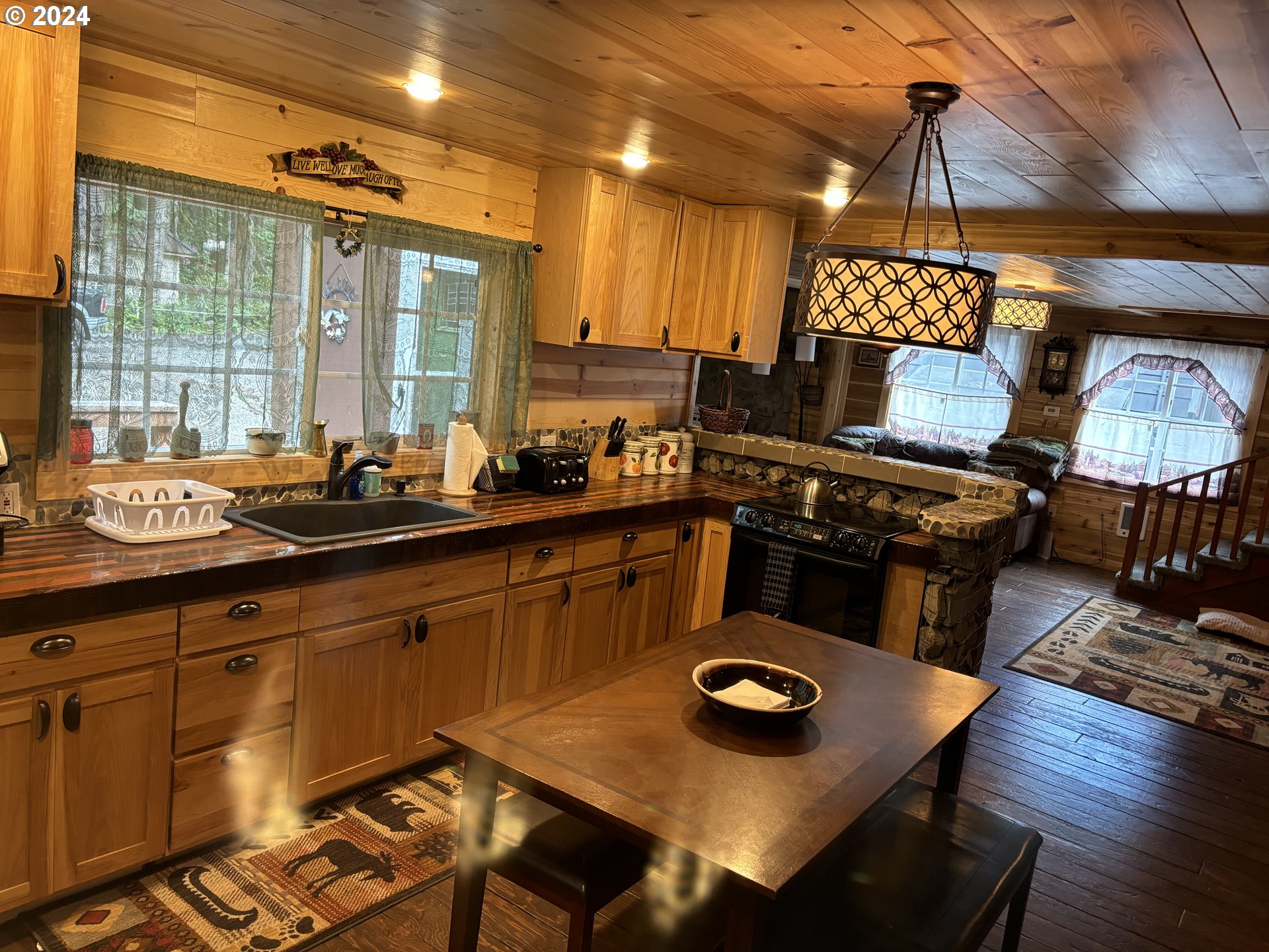 26855 East Chinook Lane Rhododendron, OR 97049 - Photo 6 of 15 a kitchen with a table chairs a stove and a microwave