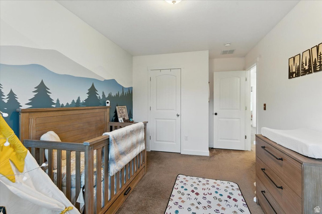 1187 Seraphim Court Layton, UT 84041 - Photo 13 of 18 Bedroom featuring a nursery area, a closet, and light colored carpet