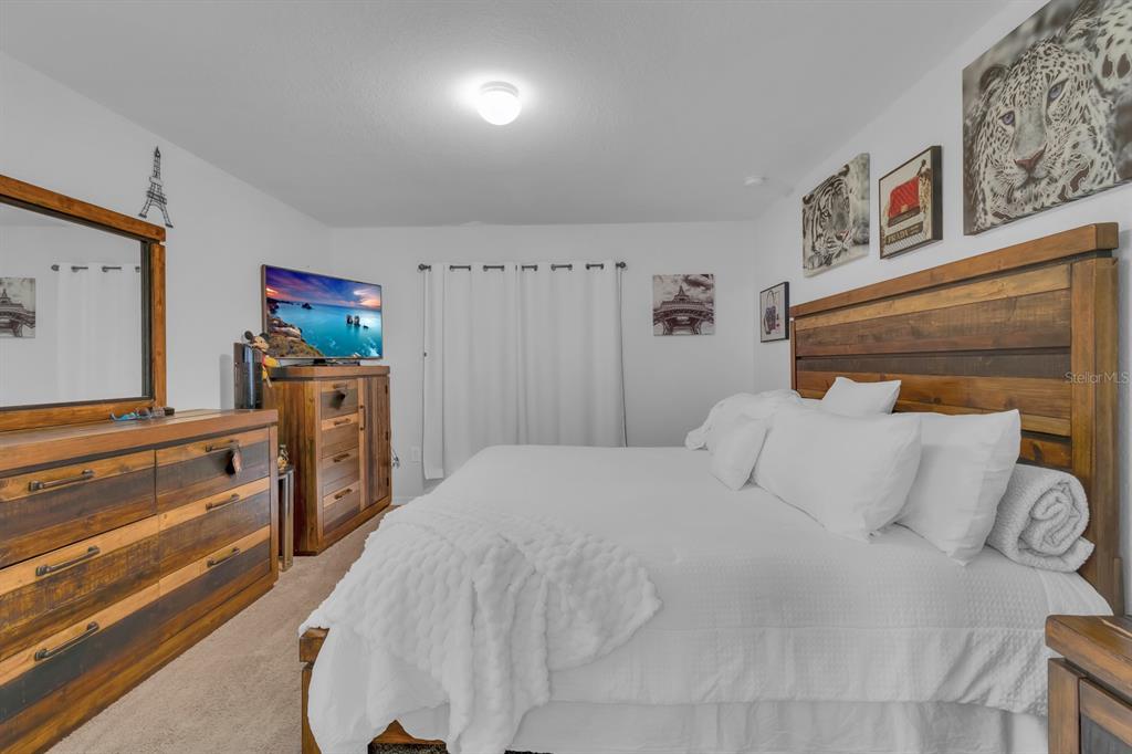 205 Arbuthnot Street Winter Haven, FL 33881 - Photo 17 of 31 a bedroom with a bed and a chandelier