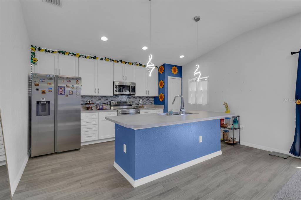 205 Arbuthnot Street Winter Haven, FL 33881 - Photo 10 of 31 a kitchen with stainless steel appliances kitchen island granite countertop a refrigerator and a sink