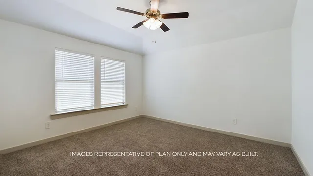 an empty room with a window and a ceiling fan