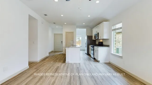 a view of a kitchen with a sink and a refrigerator