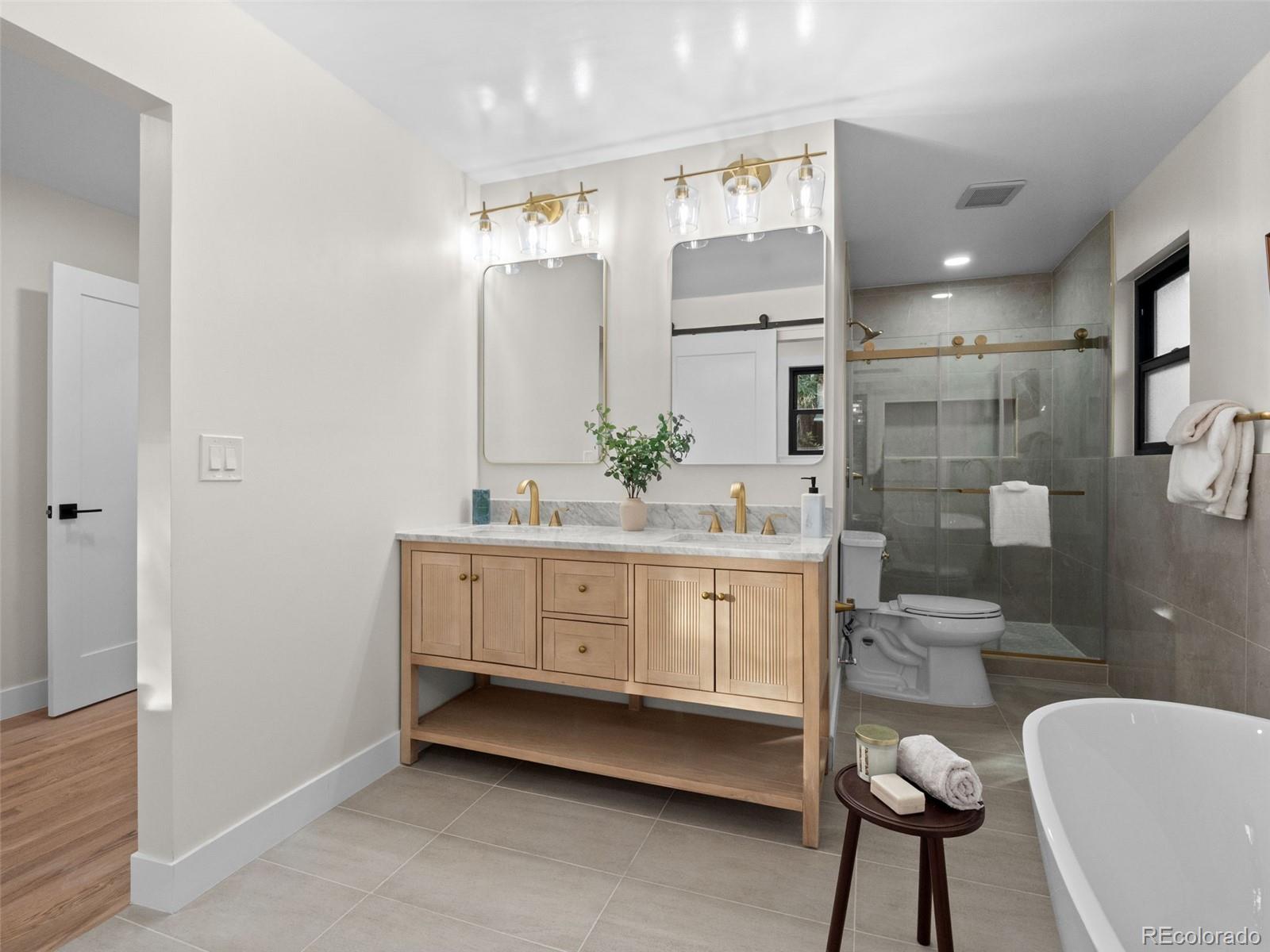 3490 Emerson Avenue Boulder, CO 80305 - Photo 14 of 31 a bathroom with a double vanity sink a toilet a mirror and shower