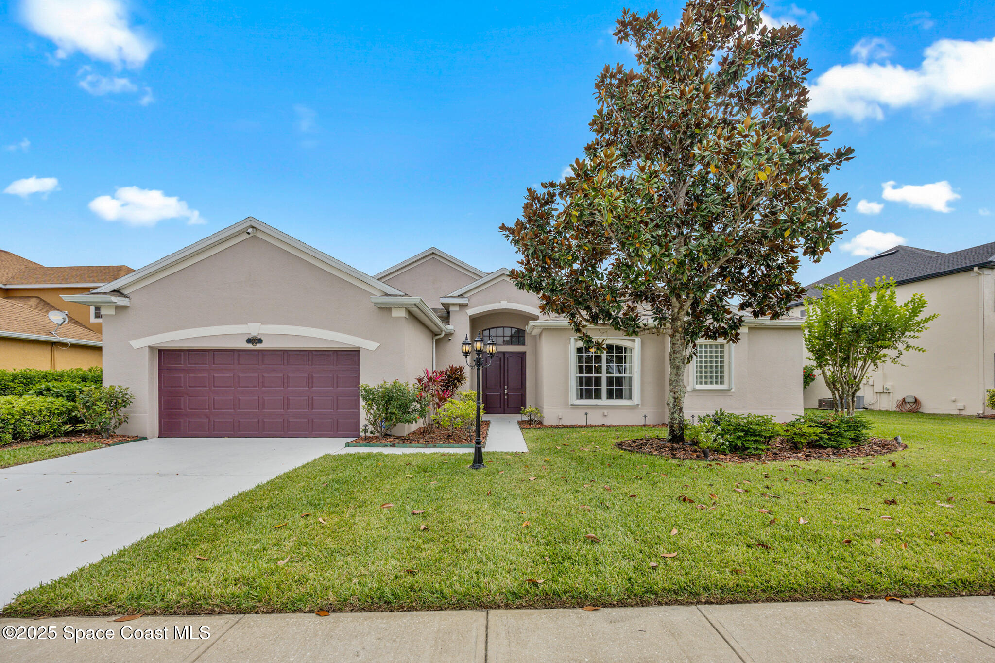 3326 Peninsula Circle Melbourne, FL 32940 - Photo 2 of 53 a front view of a house with a yard and garage