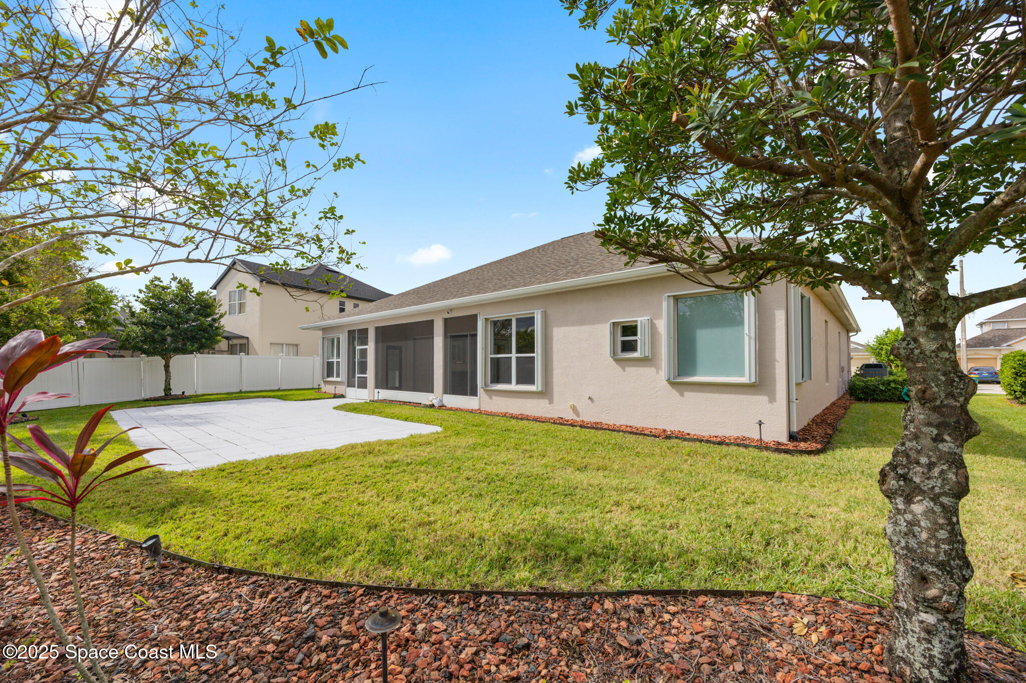 3326 Peninsula Circle Melbourne, FL 32940 - Photo 35 of 53 a view of a white house with a large tree and a yard