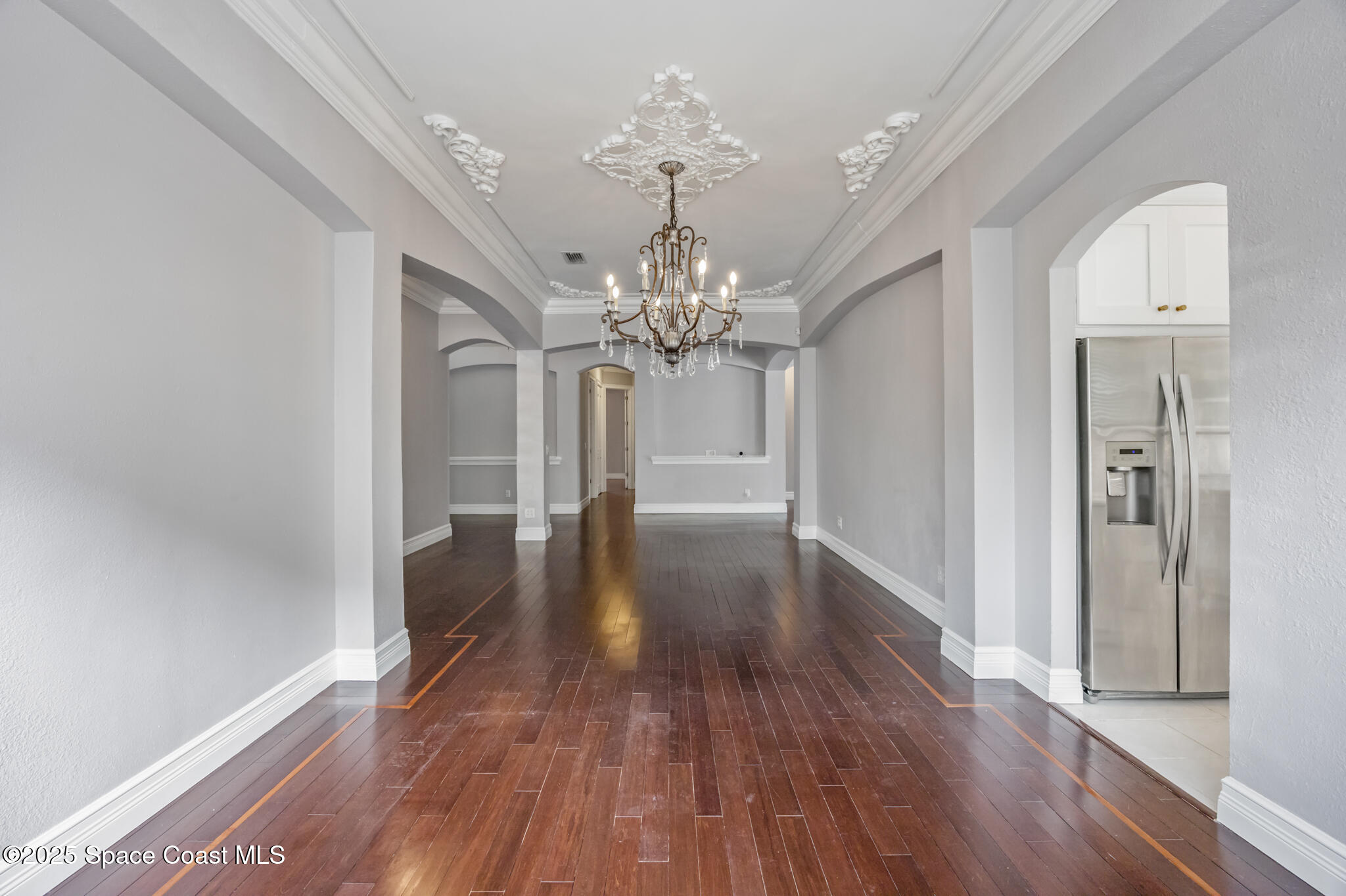 3326 Peninsula Circle Melbourne, FL 32940 - Photo 6 of 53 a view of a hallway with wooden floor and a chandelier