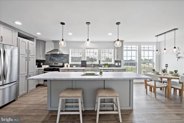 a kitchen with stainless steel appliances kitchen island granite countertop a stove a sink and a refrigerator