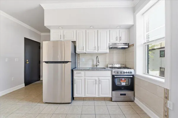 a kitchen with cabinets a refrigerator and a stove