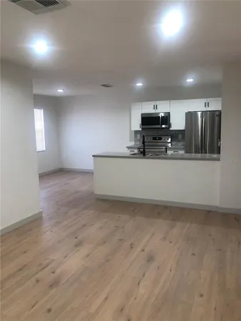 a view of kitchen with kitchen island stainless steel appliances a sink and a refrigerator