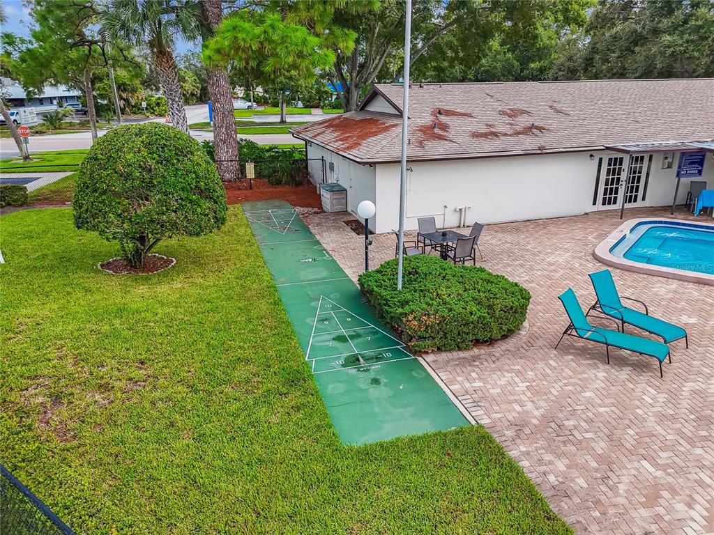 2480 Enterprise Road, Unit 6 Clearwater, FL 33763 - Photo 40 of 43 a view of a backyard with table and chairs potted plants and large tree