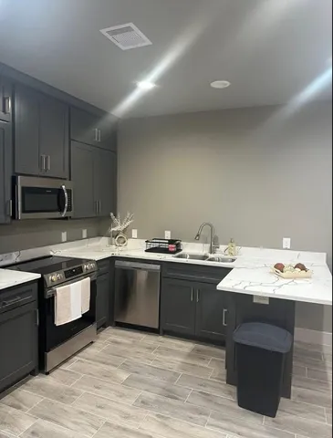 a kitchen with stainless steel appliances granite countertop a sink dishwasher stove and oven with wooden floor