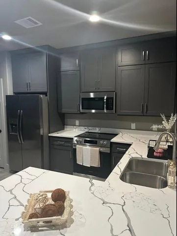 a kitchen with stainless steel appliances kitchen island granite countertop a sink stove and refrigerator
