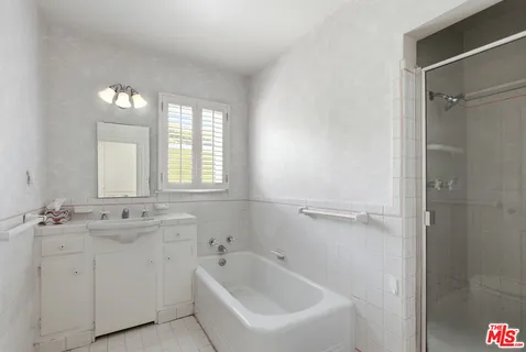 a bathroom with a bathtub sink and mirror