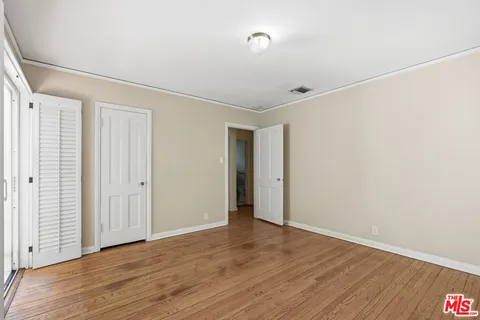 a view of an empty room with wooden floor