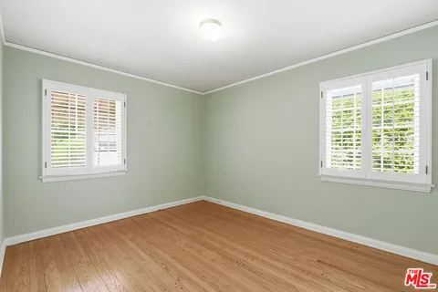 a view of a room with wooden floor and windows