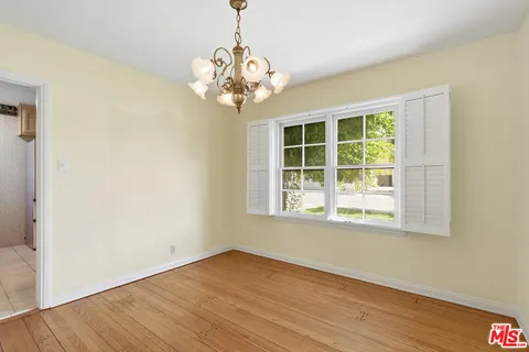 a view of a room with wooden floor and chandelier