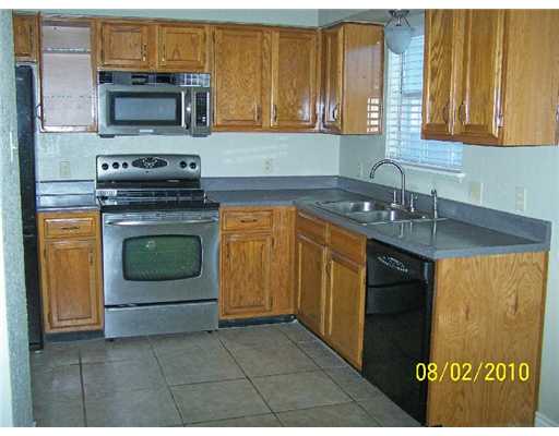 7222 Owen Court, Unit 2 Corpus Christi, TX 78413 - Photo 4 of 9 a kitchen with stainless steel appliances granite countertop a stove a sink and a microwave