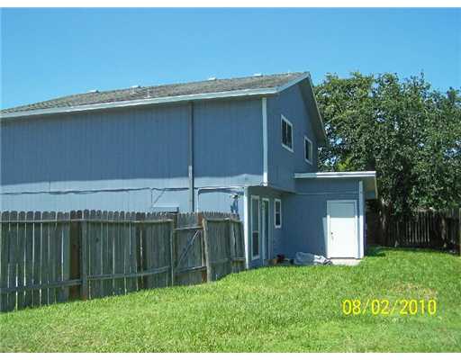 7222 Owen Court, Unit 2 Corpus Christi, TX 78413 - Photo 5 of 9 a backyard of a house with plants and a garden