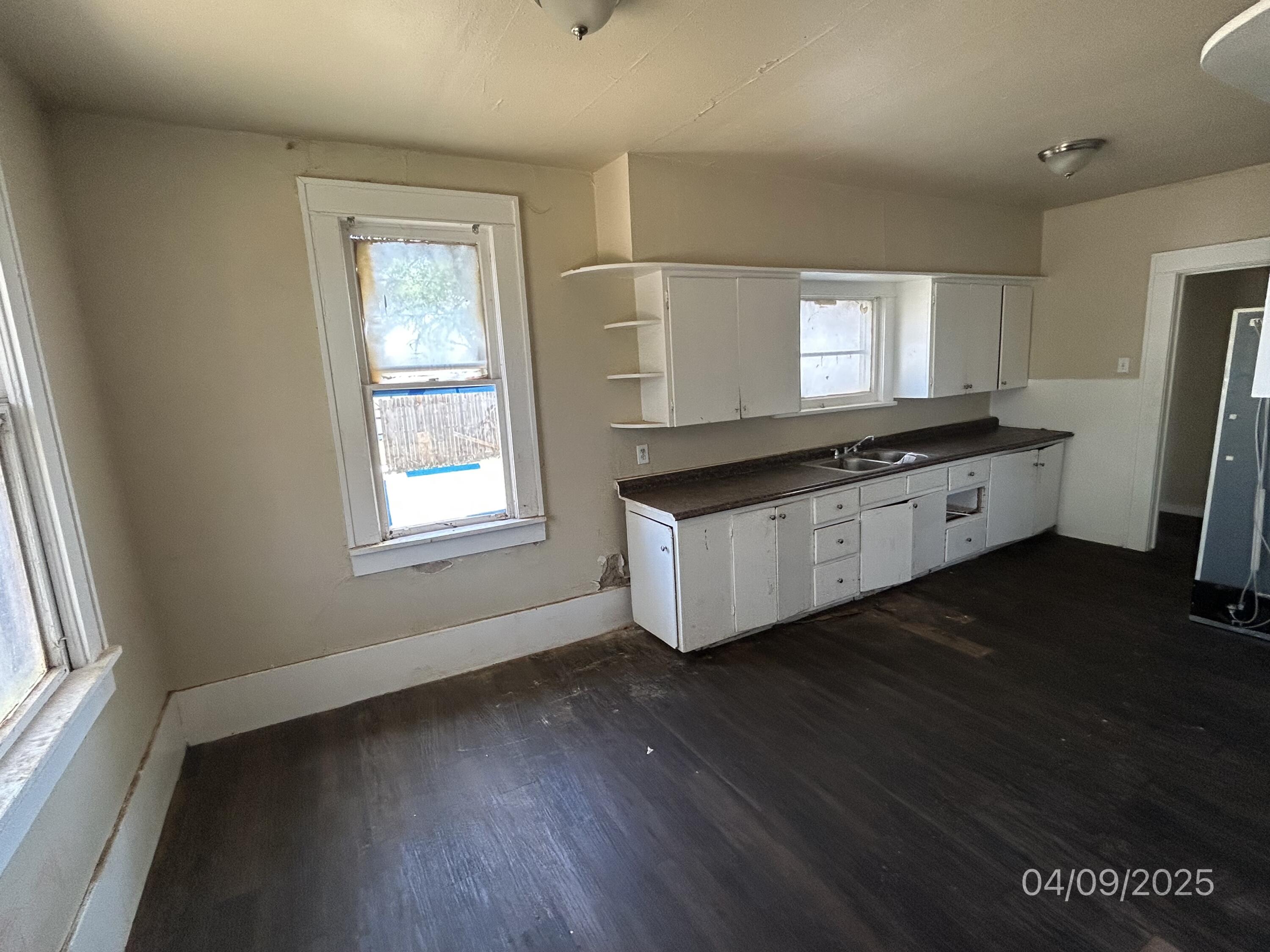 1921 Dixie Drive Lubbock, TX 79411 - Photo 7 of 19 a kitchen with stainless steel appliances granite countertop a stove a sink a refrigerator white cabinets and wooden floor