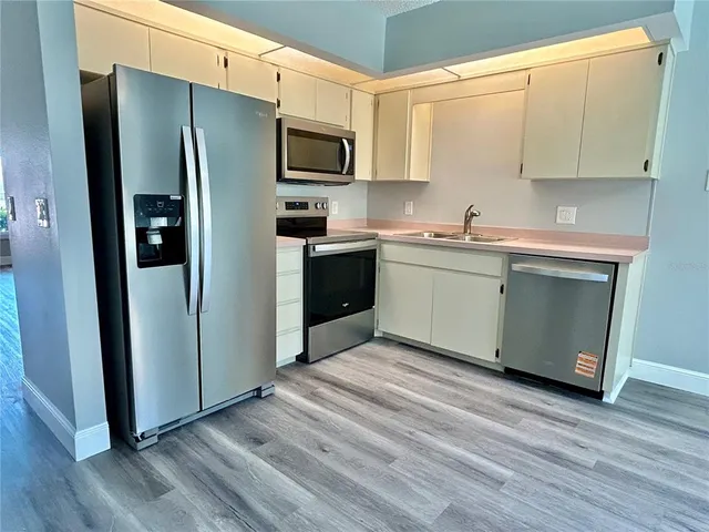 a kitchen with stainless steel appliances a refrigerator sink and microwave