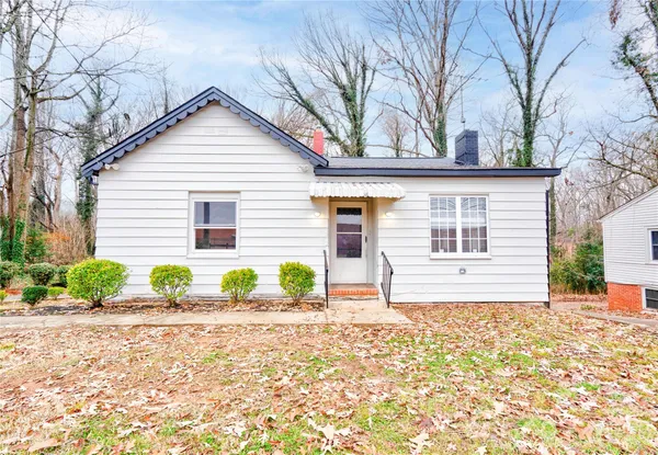 a front view of a house with a yard and potted plants