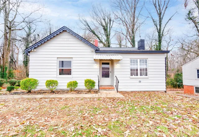 a front view of a house with a yard and potted plants