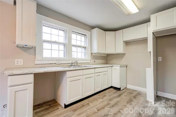 a kitchen with granite countertop white cabinets and white appliances