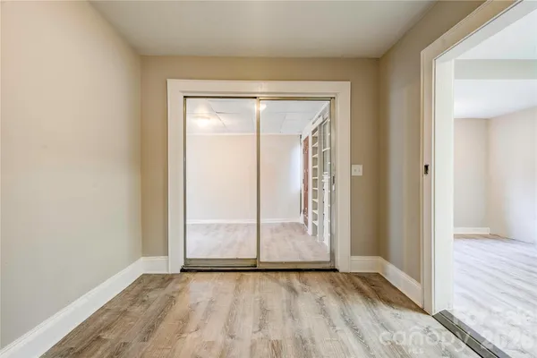 an empty room with wooden floor and door