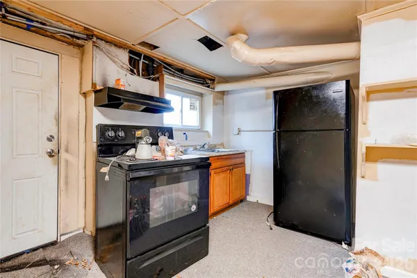 a kitchen with stainless steel appliances granite countertop a refrigerator a stove and a sink with wooden floor
