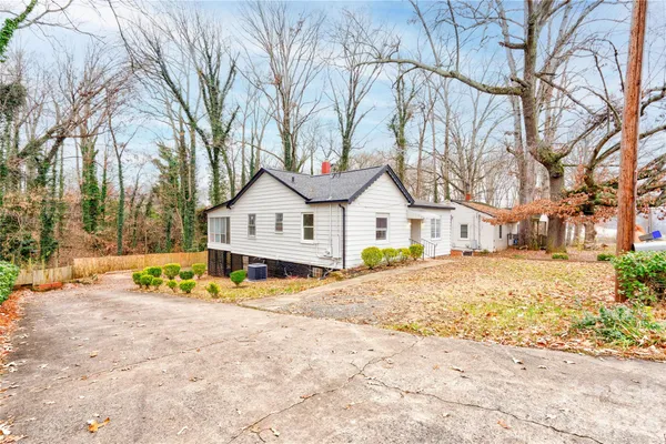 a view of white house with a yard and wooden fence