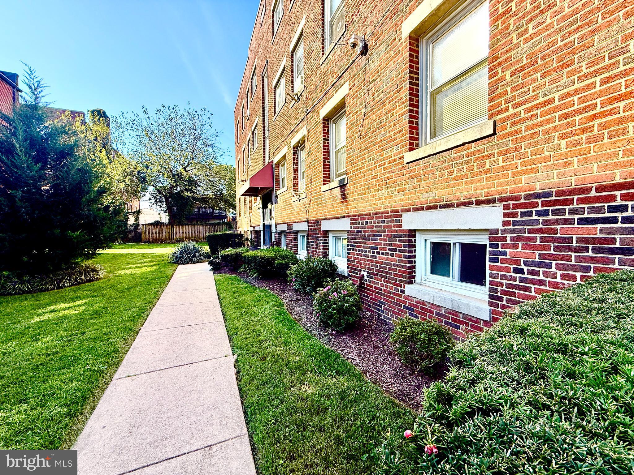 5111 Ayers Place Southeast Washington, DC 20019 - Photo 2 of 17 a front view of a brick house with a yard and many windows