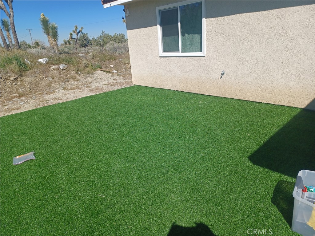 445 Solano Road Pinon Hills, CA 92372 - Photo 7 of 17 a view of a backyard with plants and large trees